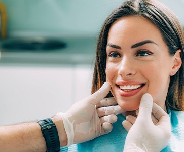 Dentist looking at smiling patient's teeth